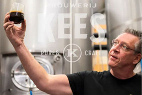 Foto di Kees Bubbermann mentre osserva una birra scura con logo del birrificio Kees sullo sfondo